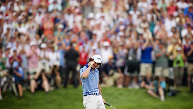 Rory McIlroy (C) of Northern Ireland celebrates after sinking his final putt and winning the 111th US Open by eight strokes over Jason Day with a record 26