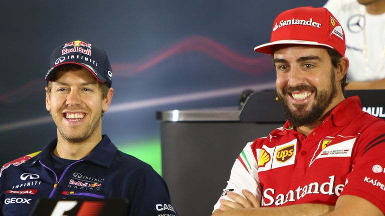 Red Bull Racing's German driver Sebastian Vettel (L) chats with Ferrari's Spanish driver  Fernando Alonso (R) during the press conference at the Yas Marina