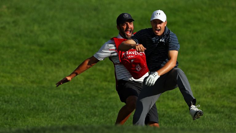 Jordan Spieth celebrates with caddie Michael Greller after chipping in for birdie from a bunker on the 18th 
