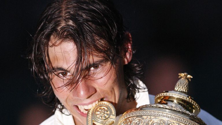 Spain's Rafael Nadal bites his trophy after defeating Switzerland's Roger Federer during their final tennis match of the 2008 Wimbledon championship