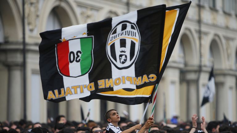 A young football fan waves a flag as Juventus' supporters gather to follow the UEFA Champions League Final football match between Juventus and Real Madrid 