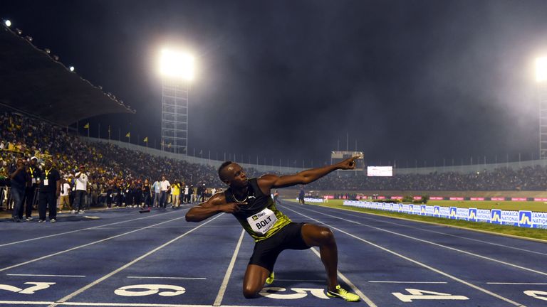 Usain Bolt (C) of Jamaica celebrates after winning 100m "Salute to a Legend " race during the Racers Grand Prix at the national stadium in Kingston, Jamaic