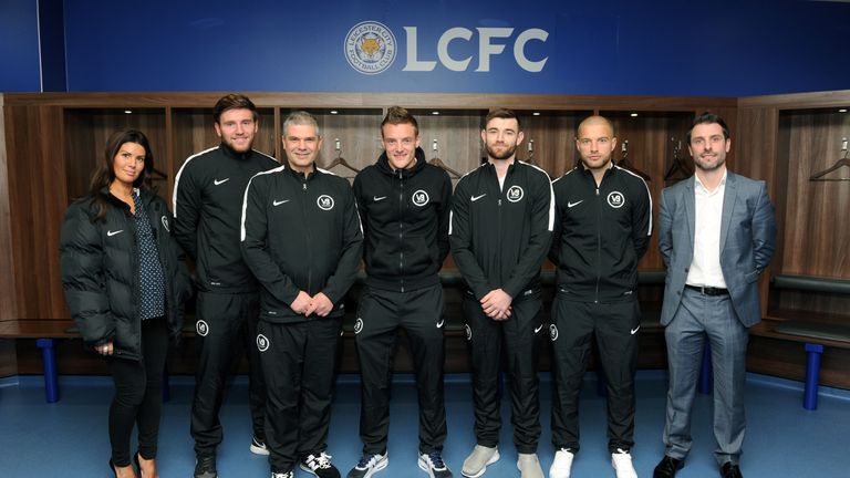 Rebekah Vardy (L), Jamie Vardy (C) and V9 co-founder John Morris (R) pose with members of the coaching staff