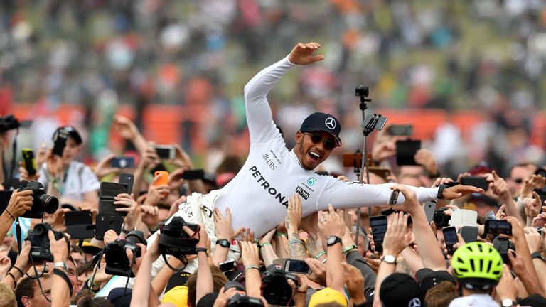 Winner Mercedes' British driver Lewis Hamilton is celebrated by fans after the British Formula One Grand Prix at the Silverstone motor racing circuit in Si