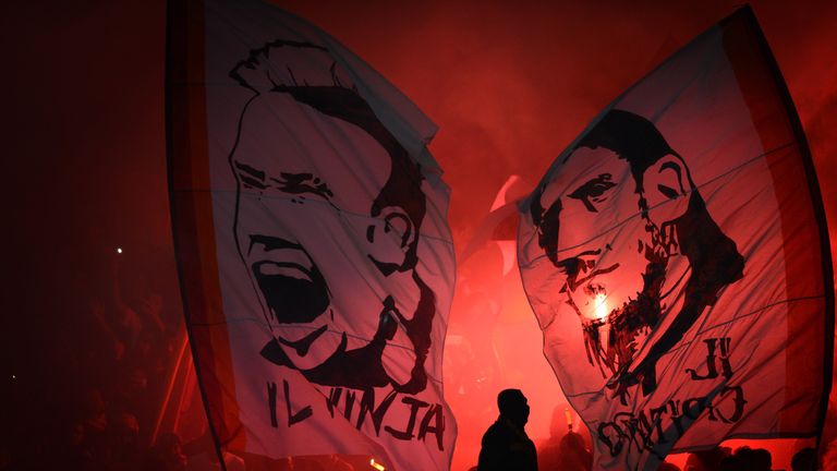 Indonesian fans light up flares and wave banners depicting the portraits of AS Roma's Italian team captain Francesco Totti and Radja Nainggolan
