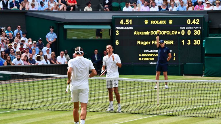 Switzerland's Roger Federer (L) shakes hands with Ukraine's Alexandr Dolgopolov (R) after Dolgopolov retired due to injury during their men's singles first