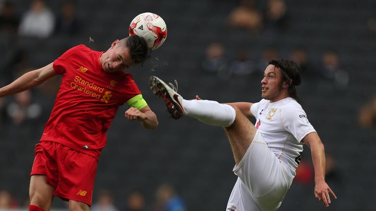 Ben Tilney of MK Dons contests the ball with Adam Phillips of Liverpool U21