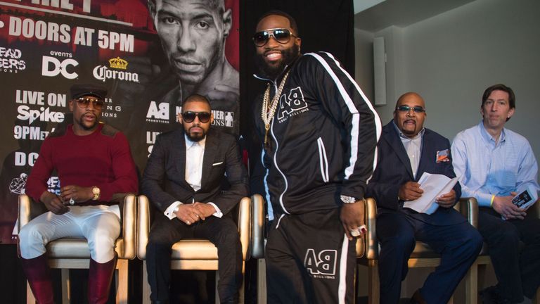 WBA super lightweight champion Adrien Broner (C) smiles as he walks past his upcoming opponent Ashley Theophane (2nd L) as promoter and former champion box