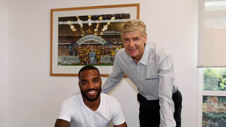 Alexandre Lacazette signs his contract with Arsenal manager Arsene Wenger at London Colney
