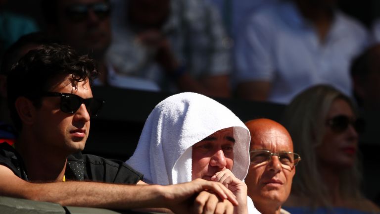 Mario Ancic (l) and Andre Agassi (r) look on as Novak Djokovic sealed his place in the last 16
