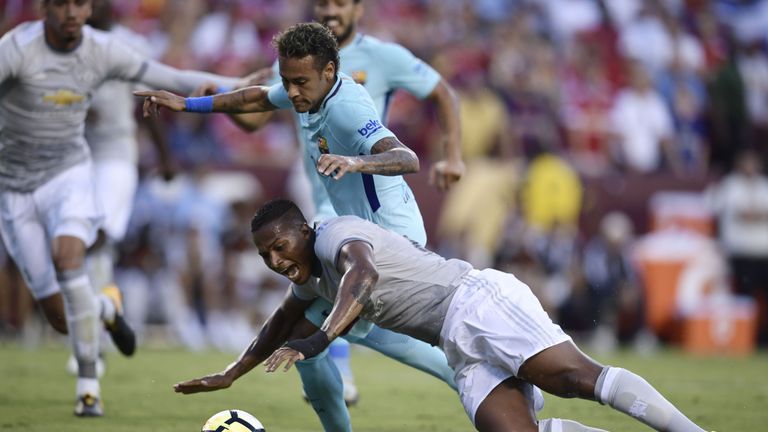 The ball eludes Antonio Valencia of Manchester United (BOTTOM) and Neymar of Barcelona (TOP) during their International Champions Cup (ICC) football match 