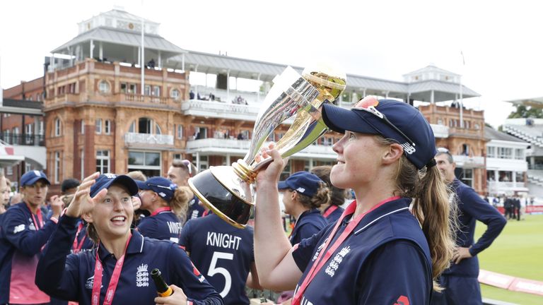 England's Anya Shrubsole (R) raises the trophy after winning the ICC Women's World Cup cricket final between England and India at Lord's cricket ground in 