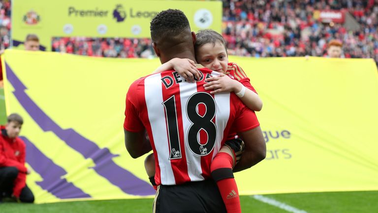 Sunderland striker Jermain Defoe (L) holds Bradley Lowery
