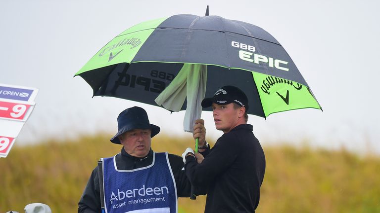 Callum Shinkwin shelters from the rain during the third round of the Scottish Open