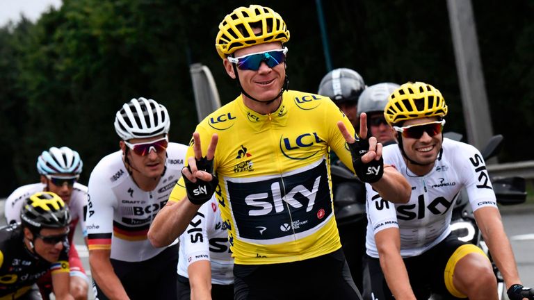 Great Britain's Christopher Froome (C) wearing the overall leader's yellow jersey flashes victory signs next to his teammate Spain's Mikel Landa (R) 