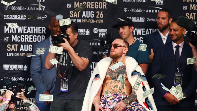 Conor McGregor looks on as money rains down during the Floyd Mayweather Jr. v Conor McGregor World Press Tour 
