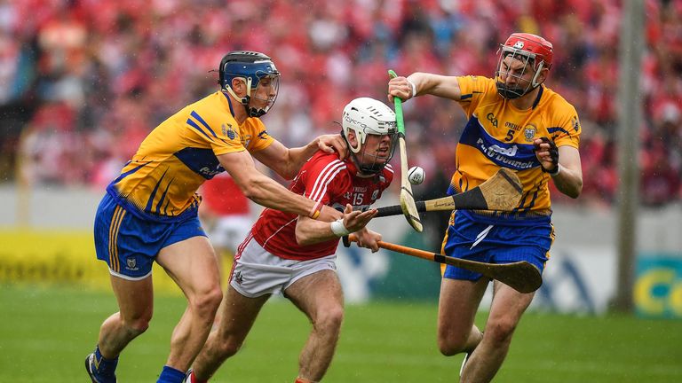 Luke Meade of Cork is tackled by David McInerney, left, and David Fitzgerald of Clare 