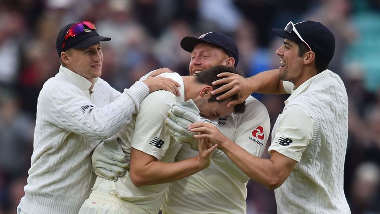 England's Toby Roland-Jones (C) celebrates wicket of South Africa's Hashim Amla for 6 runs with Joe Root (L) and Stuart Broad, 3rd Test, day two, The Oval