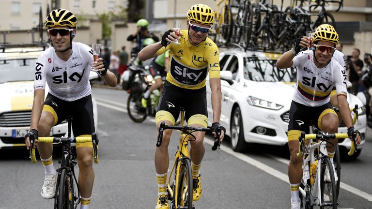 Great Britain's Christopher Froome (C) wearing the overall leader's yellow jersey, and Spain's Mikel Nieve (L) and Colombia's Sergio Henao drink champagne 