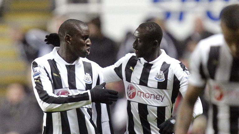 Newcastle United striker Demba Ba (L) celebrates with Papiss Cisse scoring their first goal against Wigan Athletic in the Premier League, 3 December 2012