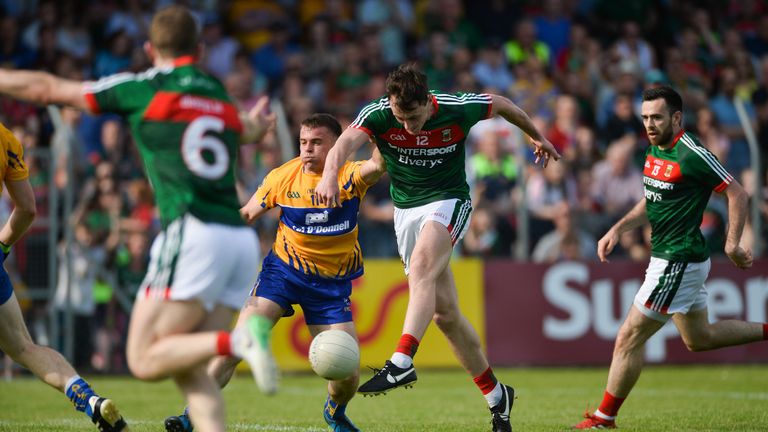 Diarmuid O'Connor of Mayo shoots to score his side's second goal despite the efforts of Sean Collins of Clare 