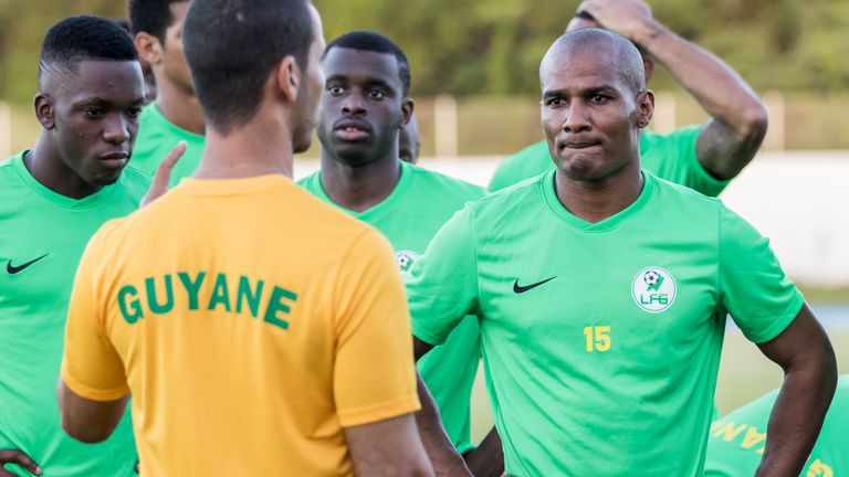 Former French national football team midfielder, Florent Malouda (R) listens to coach Jair Karam (C) as he takes part in a training session with his fellow