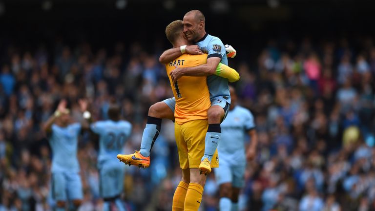 Manchester City's Argentinian defender Pablo Zabaleta (R) jumps into the arms of Manchester City's English goalkeeper Joe Hart (L) after the final whistle 