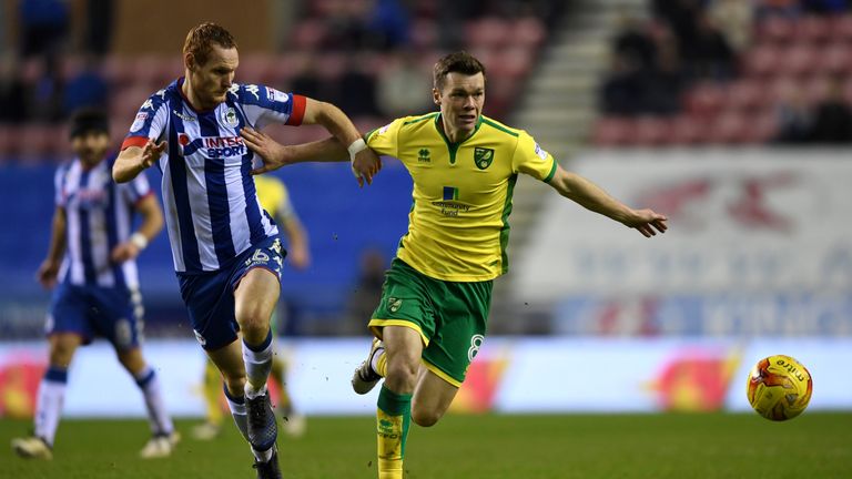 WIGAN, ENGLAND - FEBRUARY 07:  Jonny Howson of Norwich holds off Shaun MacDonald of Wigan during the Sky Bet Championship match between Wigan Athletic and 