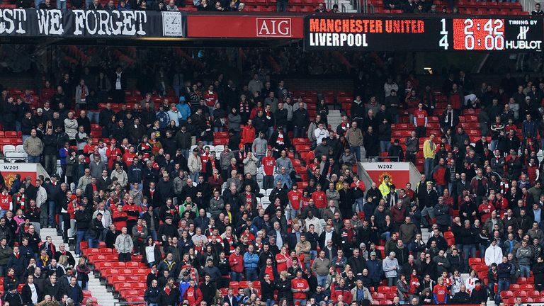 Manchester United supporters leave the ground as Liverpool take a 4-1 lead during their English Premier League football match at Old Trafford in Manchester