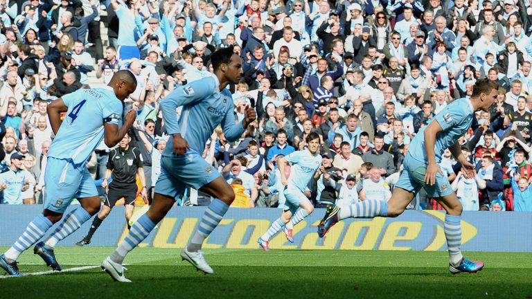 Manchester City's Bosnian striker Edin Dzeko (R) runs back to the half-way line after scoring his goal during the English Premier League football match bet