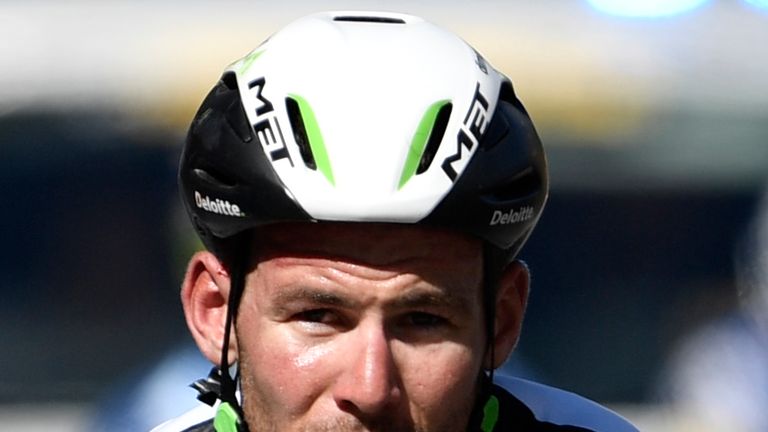 Great Britain's Mark Cavendish, injured, crosses the finish line after falling