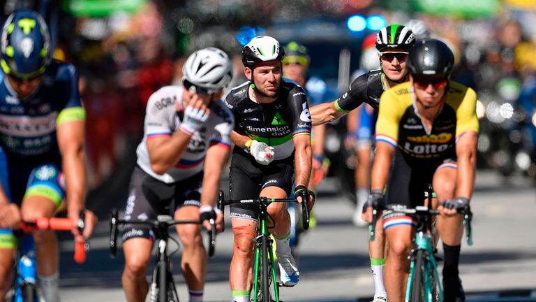 Great Britain's Mark Cavendish (C), injured, crosses the finish line after falling at the end of the 207,5 km fourth stage of the 104th edition of the Tour