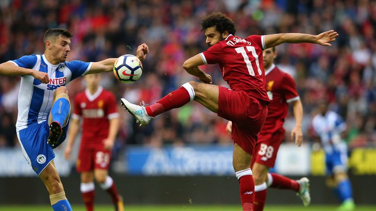 WIGAN, ENGLAND - JULY 14:  Mohamed Salah of Liverpool is tackled by Jordan Flores of Wigan Athletic during the pre-season friendly match between Wigan Athl