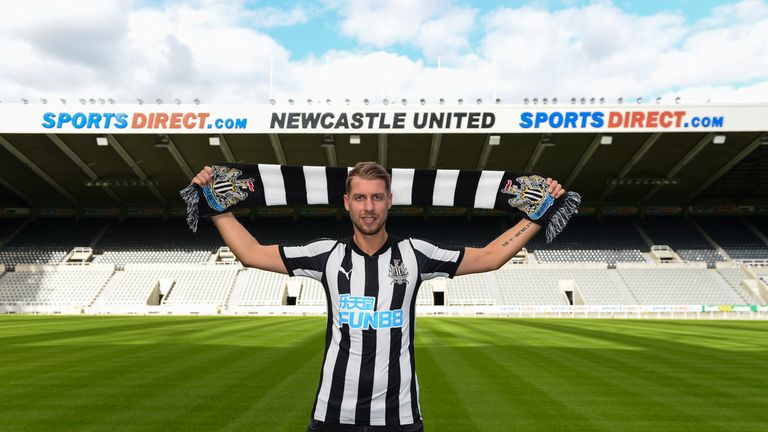 New Newcastle United signing Florian Lejeune poses for photographs pitchside holding an NUFC scarf at St. James' Park on July 3, 2017