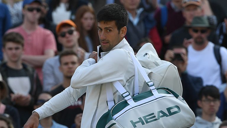 Serbia's Novak Djokovic reacts as he prepares to leave the court after retiring in his men's singles quarter-final match against returns against Czech Repu