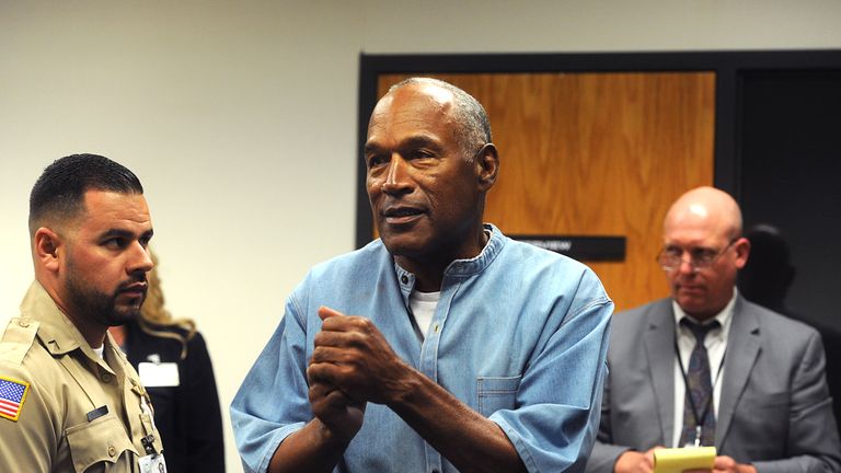 O.J. Simpson (C) reacts after learning he was granted parole