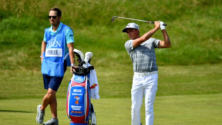 SOUTHPORT, ENGLAND - JULY 18:  Rickie Fowler of the United States hits an approach shot watched by his caddie Joe Skovron during a practice round prior to 
