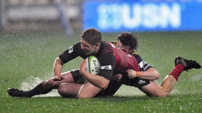 Crusaders centre Jack Goodhue is tackled by Richard Buckman