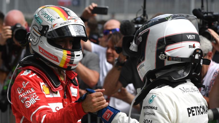 Mercedes' Finnish driver Valtteri Bottas (R) shakes hands with Ferrari's German driver Sebastian Vettel after the Formula One Austria Grand Prix at the Red