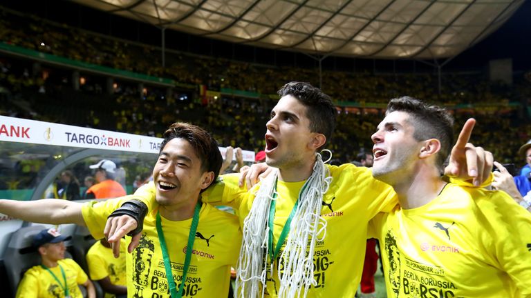 Shinji Kagawa, Marc Bartra and Christian Pulisic (L-R) celebrate after winning the DFB Cup final match between Eintracht Frankfurt and Borussia Dortmund