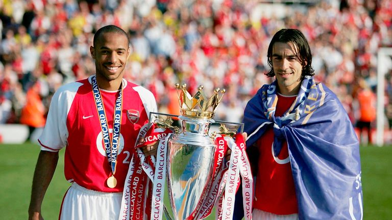 Thierry Henry and Robert Pires of Arsenal hold the Premiership trophy during the celebrations as they celebrate winning the title on May 15, 2004
