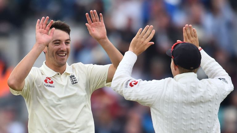 England's Toby Roland-Jones (L) celebrates the wicket of South Africa's Dean Elgar for eight runs on the second day of the third Test match