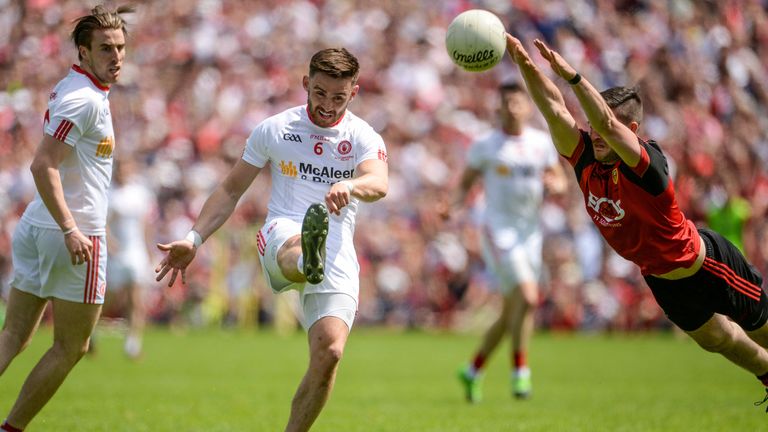 Padraig Hampsey of Tyrone beats the attempted block of Niall McParland of Down during the Ulster GAA Football Senior Championship Final match