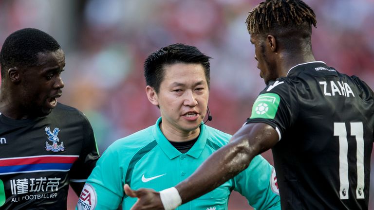 Wilfried Zaha argues with referee Ng Chiu Kok during the Premier League Asia Trophy match