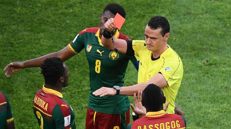 Colombian referee Wilmar Roldan (R) gives a red card to Cameroon's defender Ernest Mabouka during the 2017 FIFA Confederations Cup group B football match b