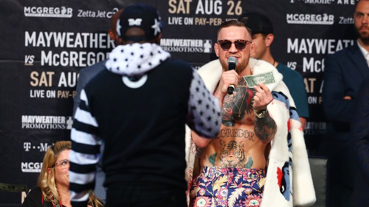 NEW YORK, NY - JULY 13:  Floyd Mayweather Jr. looks on as Conor McGregor holds a dollar bill during the Floyd Mayweather Jr. v Conor McGregor World Press T