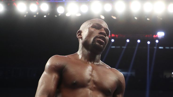 (L-R) Floyd Mayweather Jr. walks to his corner in between rounds of his super welterweight boxing match against Conor McGregor 