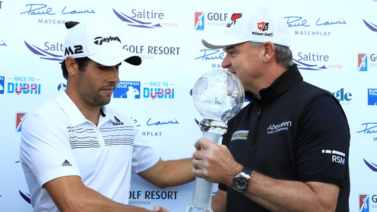 Adrian Otaegui of Spain receives the trophy from Paul Lawrie 