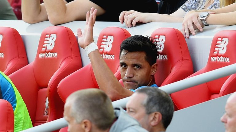 Alexis Sanchez waves from the bench after being substituted at Anfield