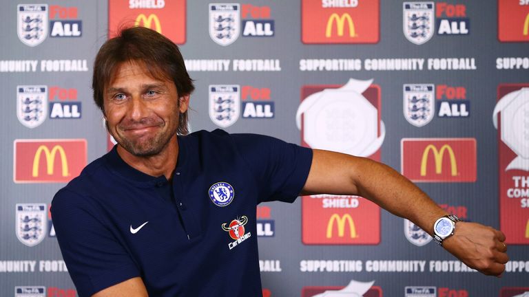 COBHAM, ENGLAND - AUGUST 04:  Antonio Conte, manager of Chelsea gestures to his watch as he makes his way into a Chelsea Press Conference at Chelsea Traini